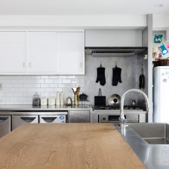 キッチンはステンレスで造作、ダイニングテーブルはオーク材、吊り戸は白メラミン材を使用。